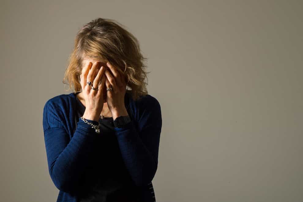 EMBARGOED TO 0001 FRIDAY NOVEMBER 17 PICTURE POSED BY A MODEL File photo dated 09/03/15 of a woman with her hands covering her face. Women should be offered talking therapy on the NHS to combat the symptoms of menopause, according to new guidance. Issue date: Friday November 17, 2023.