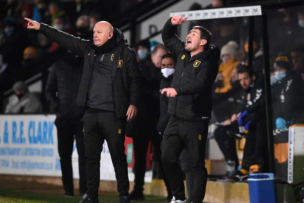 Mansfield Town manager Nigel Clough (right) and first team coach Andy Garner instructs their players during the Sky Bet League Two match at Abbey Stadium, Cambridge.