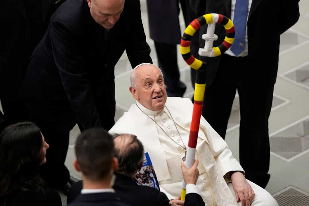 Pope Francis is presented with a pastoral staff made in Uganda (AP)