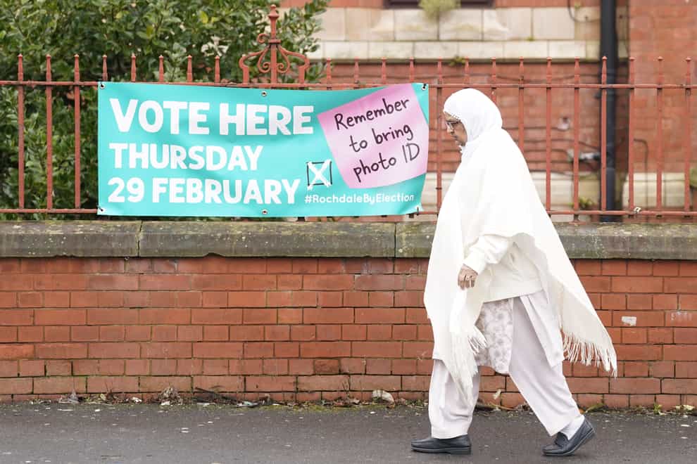 A woman walks past a sign for a polling station location in Rochdale, Greater Manchester (Danny Lawson/PA)