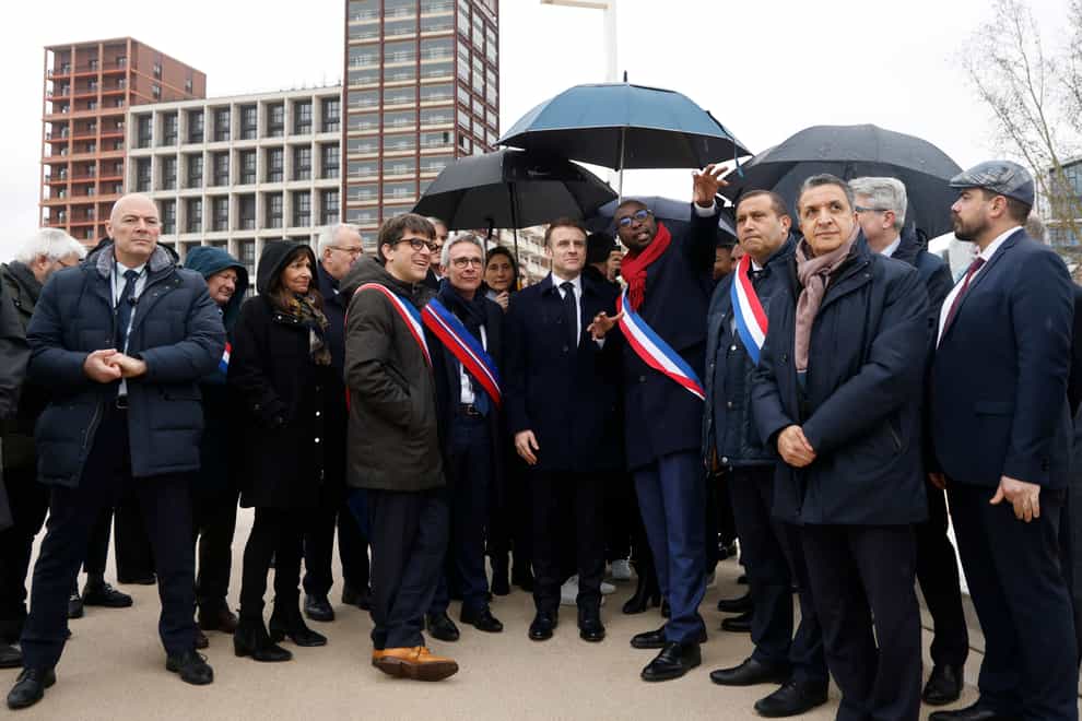 France’s President Emmanuel Macron, surrounded by officials, attends the inauguration ceremony of the Paris 2024 Olympic village in Saint-Denis (Ludovic Marin, Pool via AP)