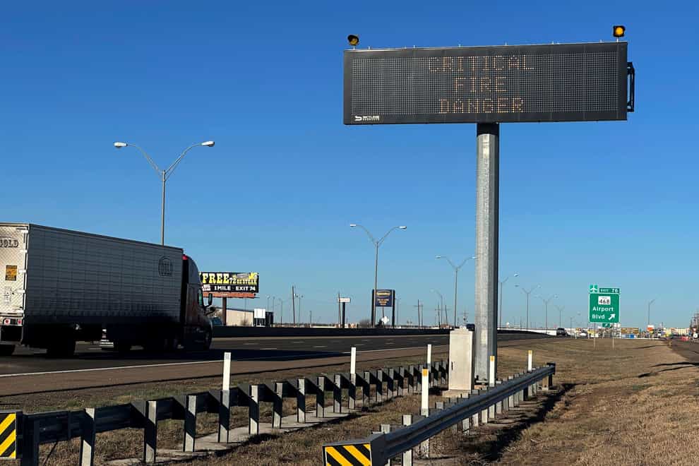 A truck passes a warning sign about the Smokehouse Creek Fire on a highway in Amarillo (Ty O’Neil/AP)
