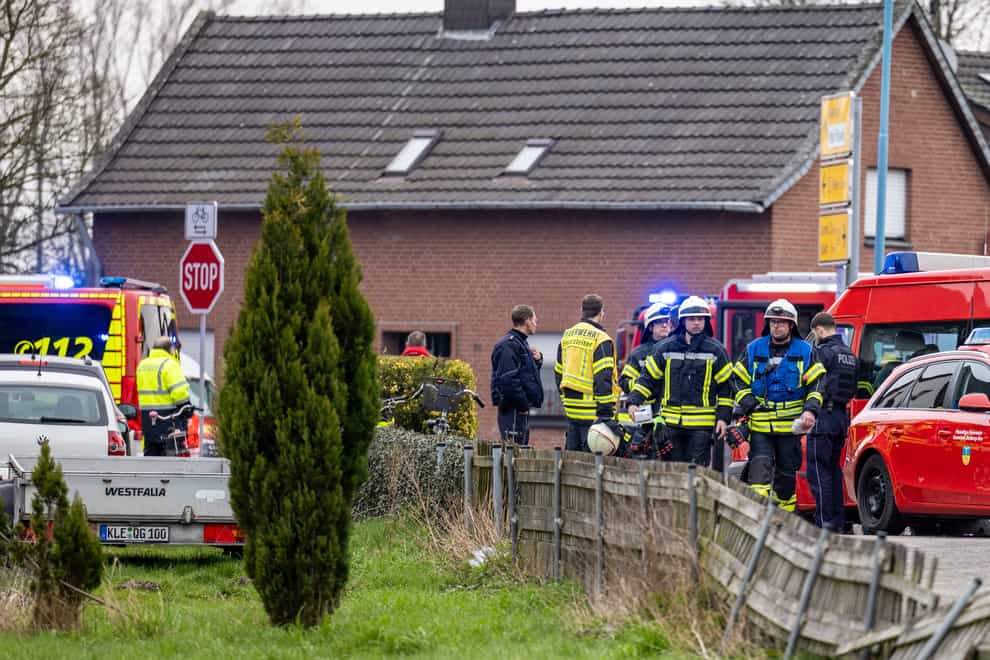 Police and fire department personnel stand by a retirement home after a fire broke (Christoph Reichwein/dpa via AP)