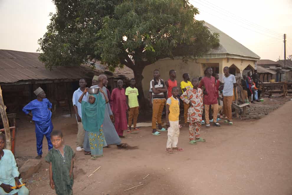 People gather around an area were gunmen kidnapped school children in Chikun, Nigeria (AP)