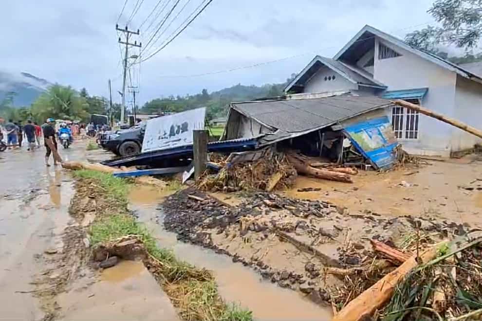 Torrential rains have triggered flash floods and a landslide on the Indonesian island of Sumatra, killing 19 people with a further seven still missing (AP)