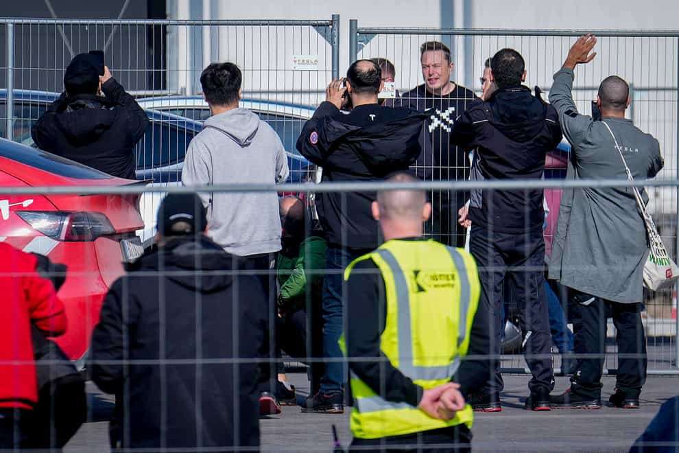 Tesla CEO Elon Musk, fourth from right, arrives at the Tesla Gigafactory for electric cars in Gruenheide near Berlin, Germany (Ebrahim Noroozi/AP)