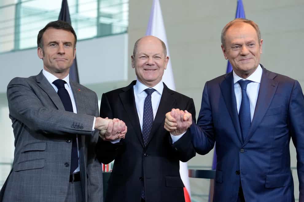 German Chancellor Olaf Scholz, centre, French President Emmanuel Macron, left, and Poland’s Prime Minister Donald Tusk shake hands at a press conference in Berlin, Germany, on Friday (Ebrahim Noroozi/AP)