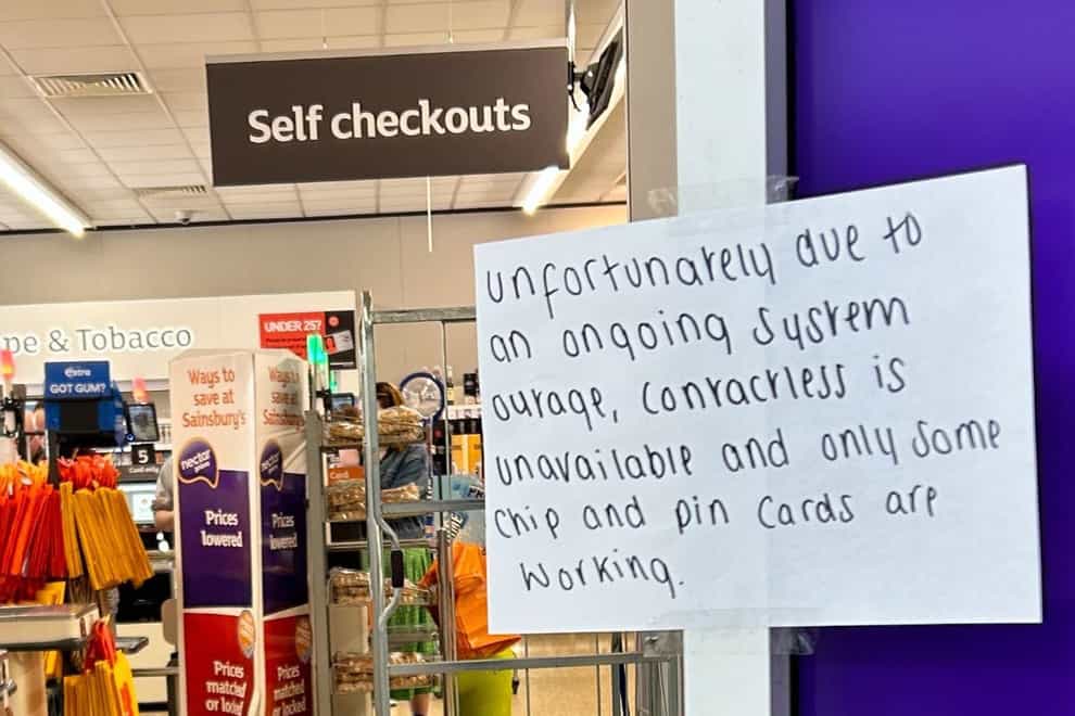 A hand written notice informing customers of technical issues at a Sainsbury’s in Huddersfield (Ashley Broadley/PA)