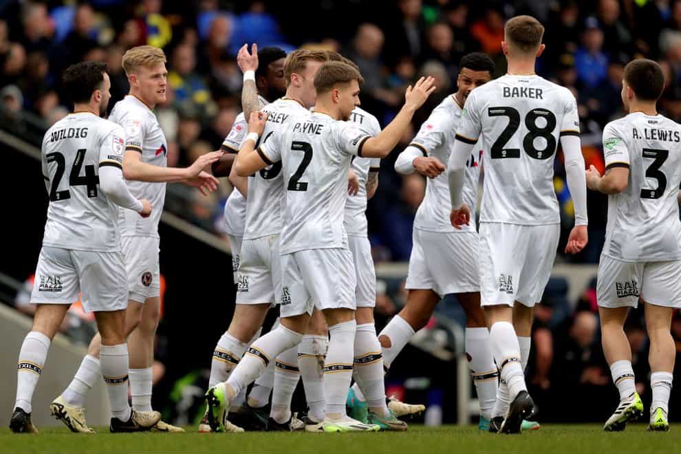 Newport County’s Bryn Morris celebrates after scoring their first goal with teammates during the Sky Bet League Two match at the Cherry Red Records Stadium, London. Picture date: Saturday March 16, 2024.