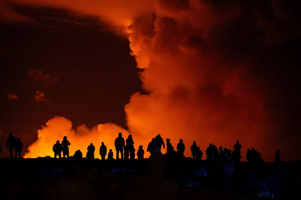 Spectators watch plumes of smoke from volcanic activity (Marco di Marco/AP)