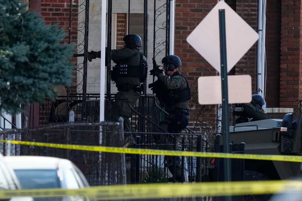 Police officers entering a home in Trenton, New Jersey, on Saturday (Matt Rourke/AP)