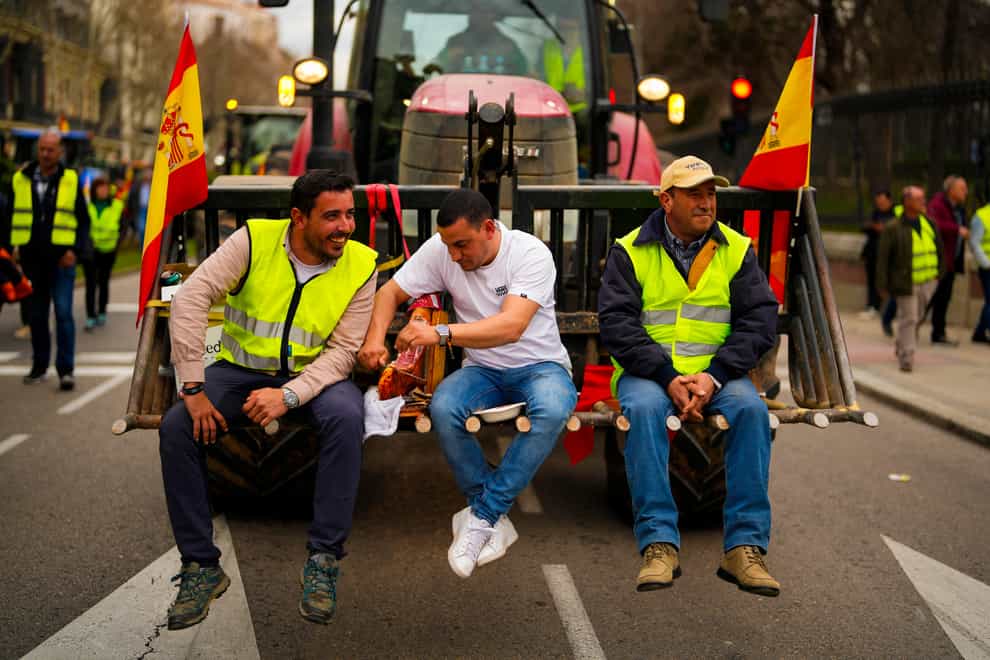 Farmers sit on a tractor during a protest in Madrid, Spain (AP)