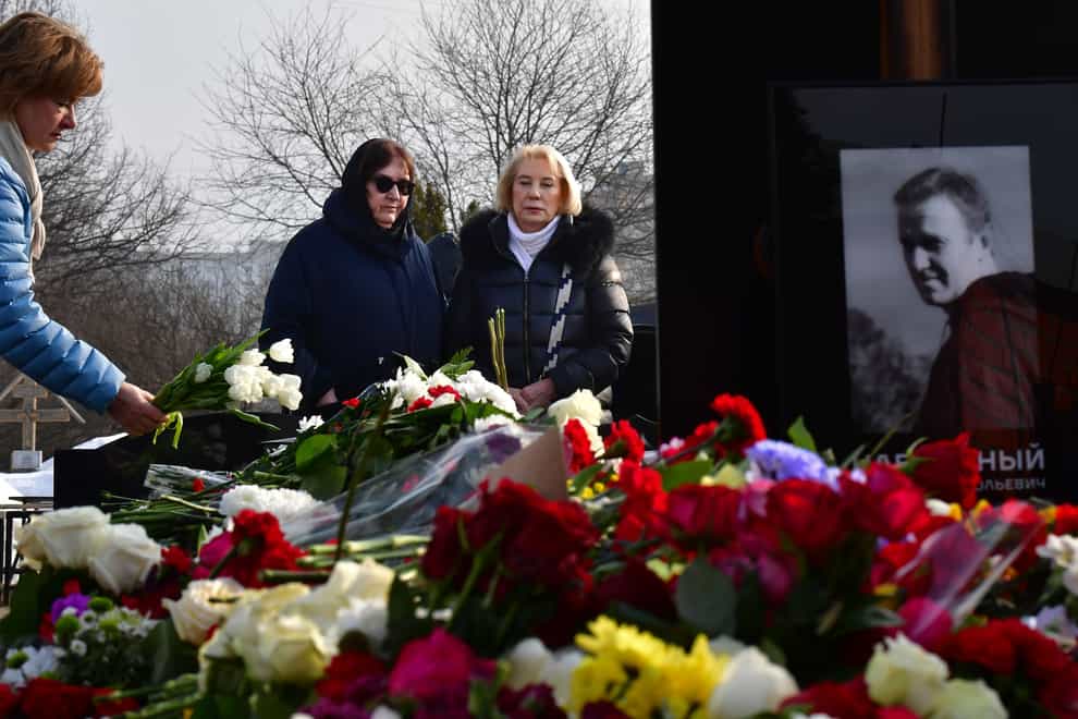 Russian opposition leader Alexei Navalny’s mother, Lyudmila Navalnaya, centre left, and his mother-in-law Alla Abrosimova visit his grave at the Borisovskoye Cemetery in Moscow (AP)