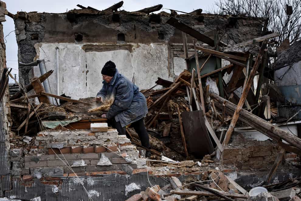 Inna, 71, clears the rubble after her house was destroyed by a Russian drone attack in in Zaporizhzhia (AP Photo/Andriy Andriyenko)