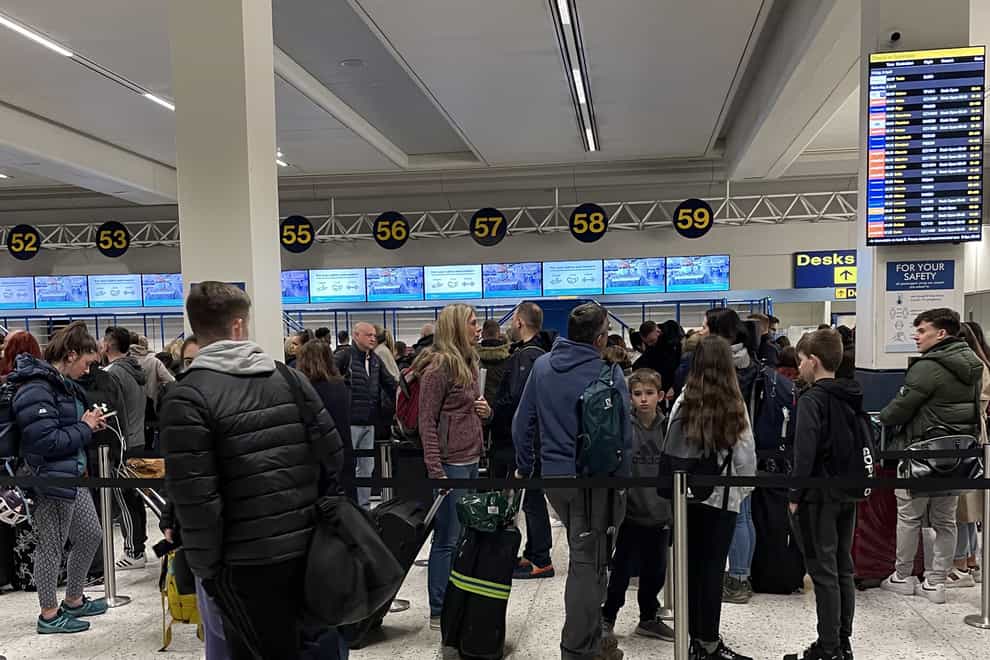 Passengers queue inside the departures area of Terminal 1 at Manchester Airport (PA)
