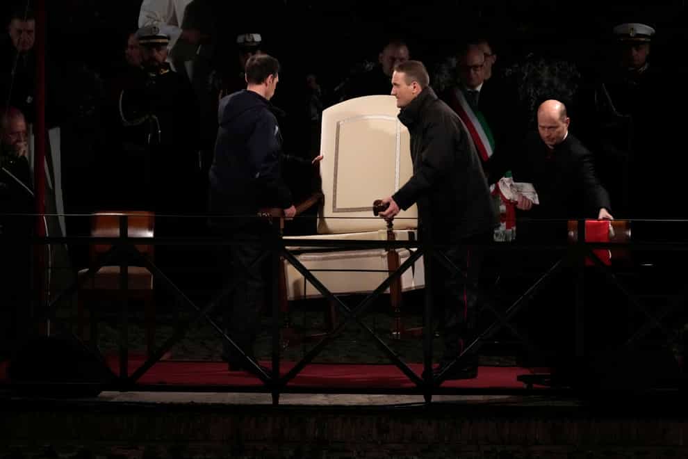 Vatican ushers carry Pope Francis’s chair prior to the start of the Via Crucis at the Colosseum on Good Friday (AP Photo/Gregorio Borgia)