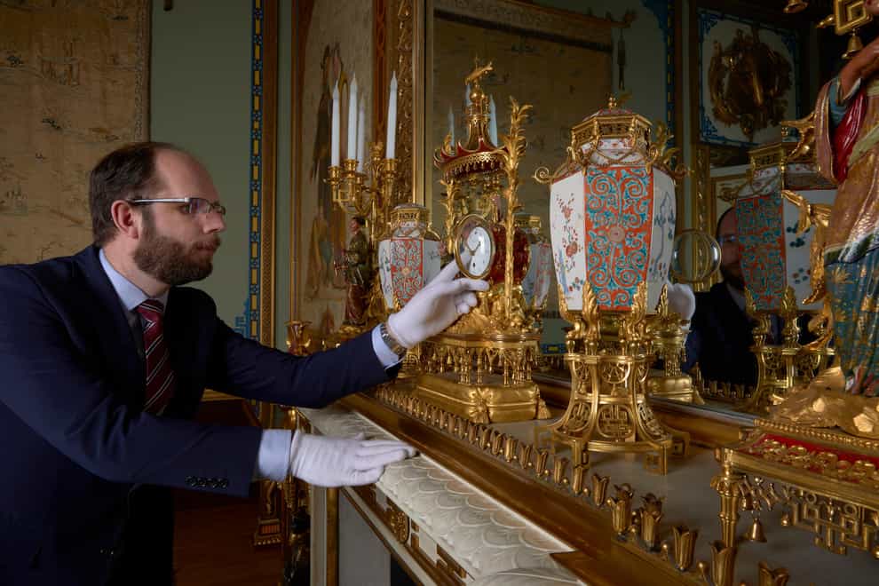 A horological conservator adjustsa late-18th-century French mantelclock at Buckingham Palace (Royal Collection Trust/PA)