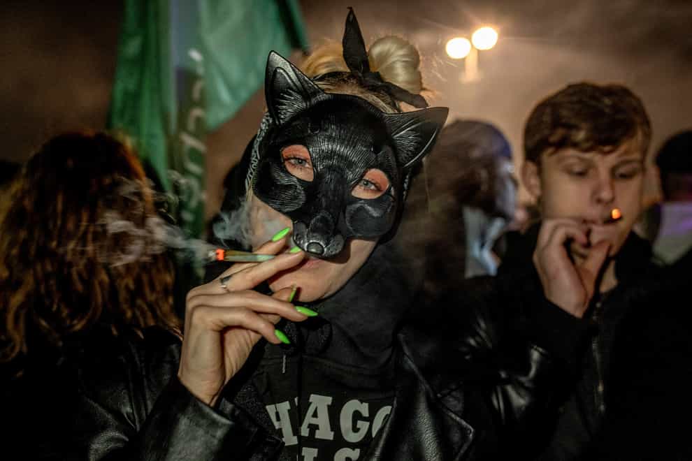 People smoke cannabis in front of the Brandenburg Gate (Ebrahim Noroozi/AP)