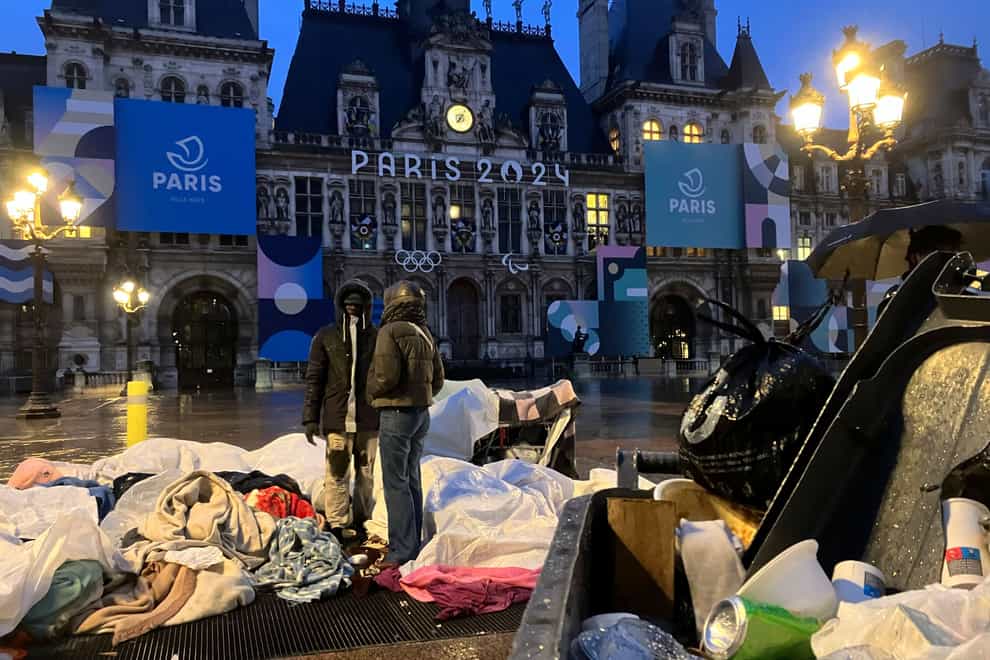 Migrants stand in front of Paris City Hall (Nicolas Garriga/AP)