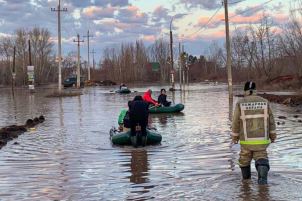 People use boats to evacuate after part of a dam burst, causing flooding in Orsk, Russia (Administration of the city of Orenburg Telegram Channel via AP)