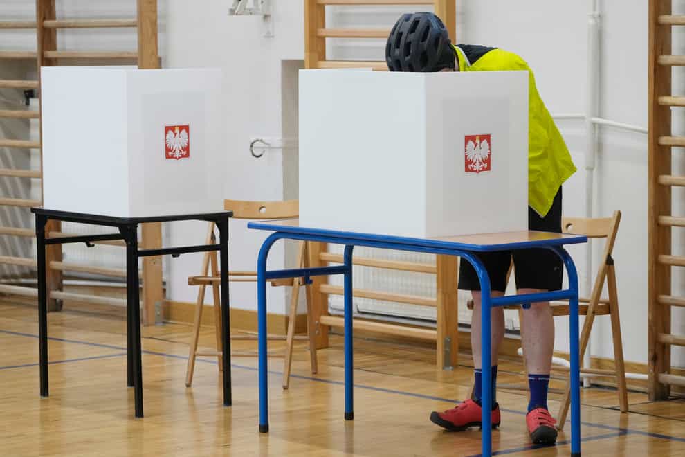 A man casts his ballot during local elections in Warsaw, Poland (Czarek Sokolowski/AP)