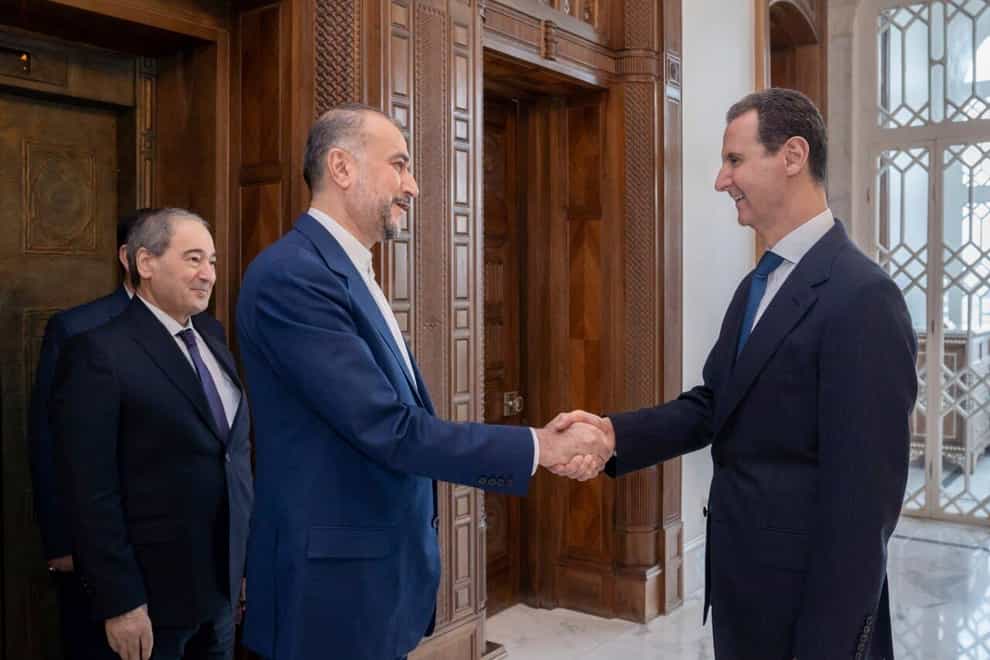 Syrian President Bashar Assad, right, welcomes Iranian Foreign Minister Hossein Amirabdollahian before their meeting in Damascus, Syria (Syrian Presidency Telegram page via AP)