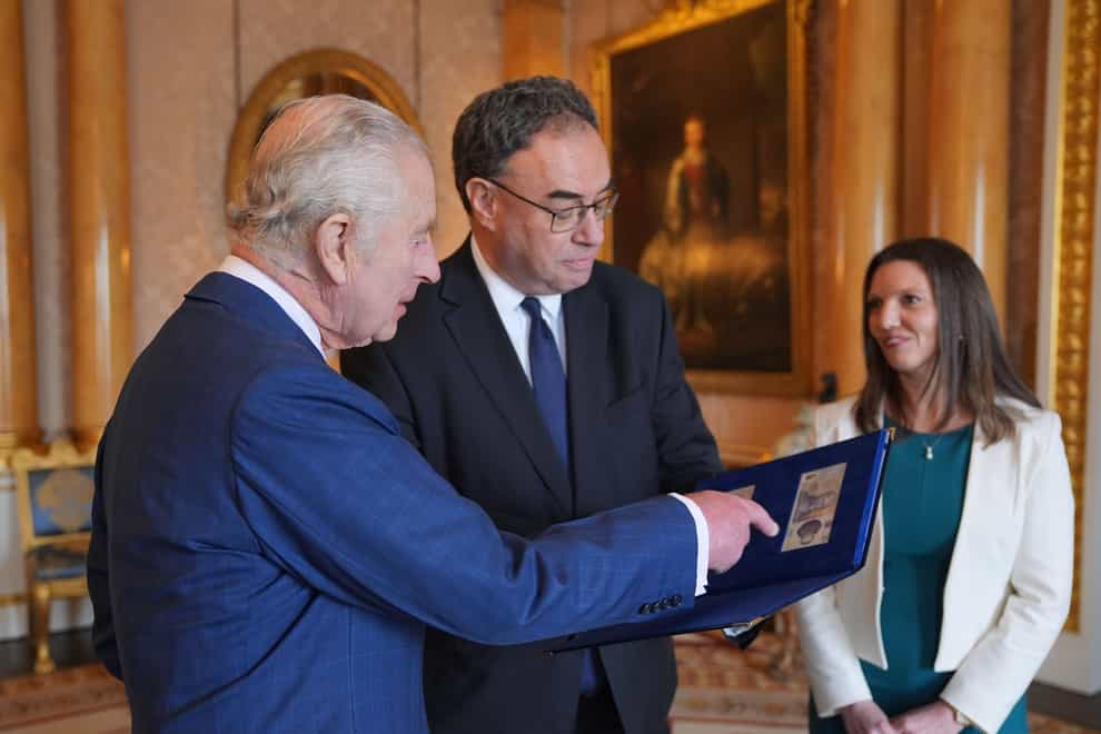 The King has been presented with the first banknotes bearing his portrait by the Governor and Chief Cashier of the Bank of England at Buckingham Palace (Yui Mok/PA)