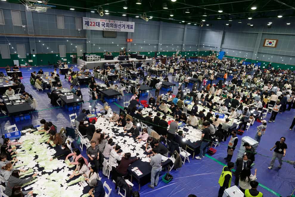 National Election Commission officials sort out ballots for counting at the parliamentary election in Seoul (Lee Jin-man/AP)