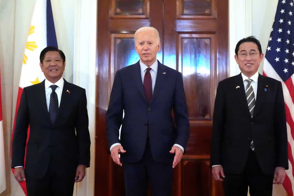 President Joe Biden, centre, Philippine President Ferdinand Marcos Jr., left, and Japanese Prime Minister Fumio Kishida pose before a trilateral meeting in the East Room of the White House in Washington (Mark Schiefelbein/AP)