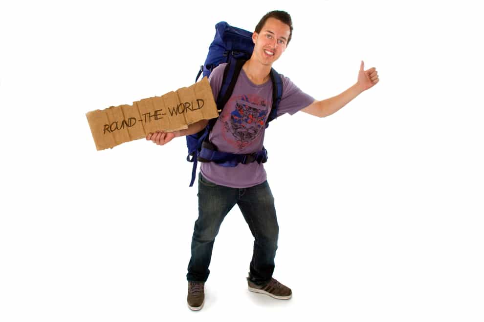 Hitchhiker with backpack and sign (Alamy/PA)
