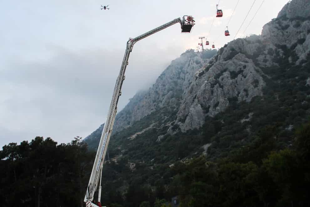A rescue team helps passengers on the cable car (IHA via AP)