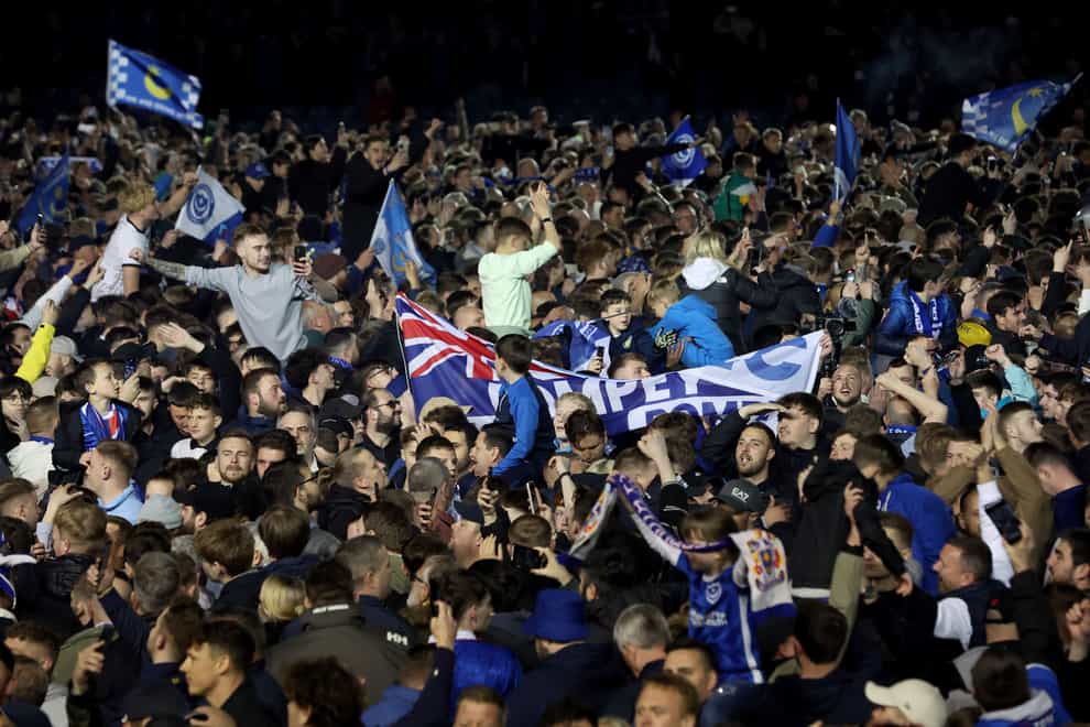 Portsmouth fans celebrate on the pitch after their team secured promotion (Steven Paston/PA)