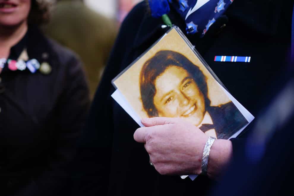 An attendee holds photograph of Pc Yvonne Fletcher during a 40th anniversary memorial service in St James’s Square, London (Victoria Jones/PA)