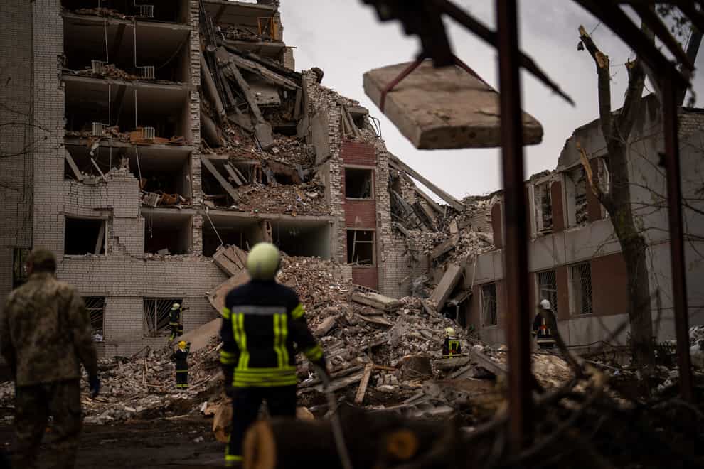 Firefighters work on a building that was partially destroyed after a Russian bombardment in Chernihiv, Ukraine (Francisco Seco/AP)