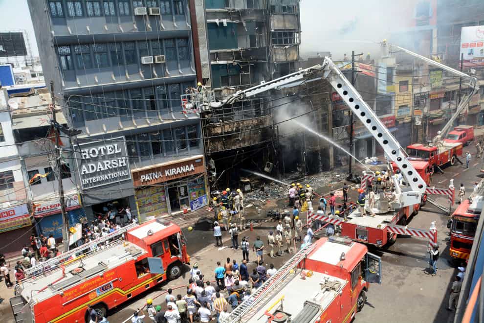 Firefighters douse a fire which broke out in a restaurant and hotel near the Patna Junction railway station (Aftab Alam Siddiqui/AP)