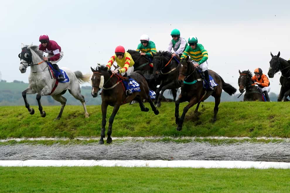 Singing Banjo ridden by jockey Barry Walsh (second left) clears Ruby’s Double on their way to winning the Mongey Communications La Touche Cup Cross Country Chase (Brian Lawless/PA)